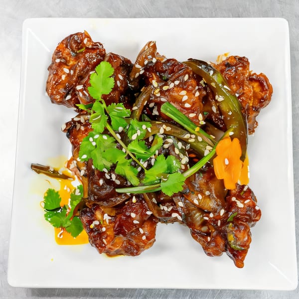 Palace Indian Restaurant's chili chicken, garnished with sesame seeds, cilantro, and green chilies.